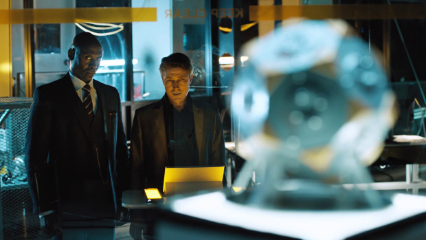 The live-action segments focus on the sinister corporation Monarch, led by Aiden Gillen's Paul Serene (centre).
