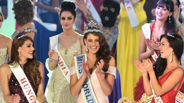 On top of the world: Rolene Strauss celebrates with Miss Hungary and Miss United States as Miss India looks on.