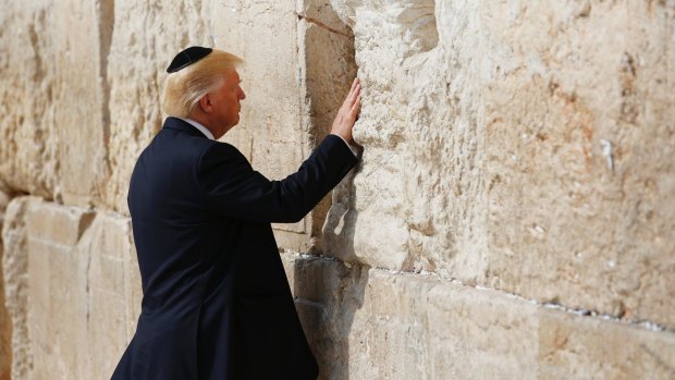 US President Donald Trump touches the Western Wall, Judaism's holiest prayer site, in Jerusalem's Old City on Monday.
