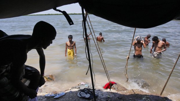 Bangladeshi men wash themselves in the sea at a temporary shelter in Langsa, Aceh province, Indonesia.