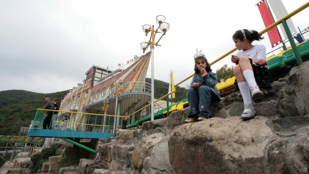 Two girls sit by the ship-shaped Eclectic Hotel in Vank.