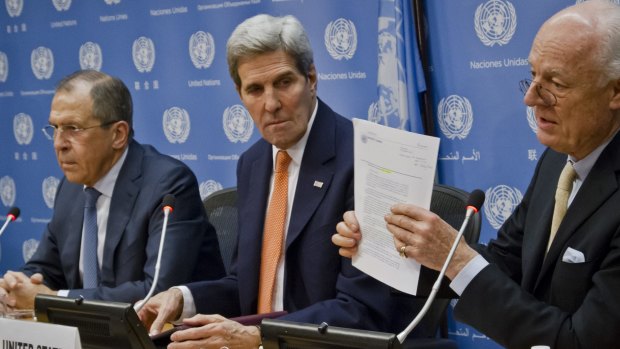 UN special envoy for Syria Staffan de Mistura (right)  shows the Security Council resolution on Syria, during a press conference with Russian Foreign Minister Sergey Lavrov (left) and US Secretary of State John Kerry.