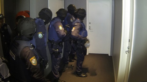 Police carry out one of the early morning raids.