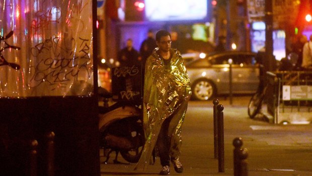 A survivor walks in the street after gunfire in the Bataclan concert hall in Paris, France. 