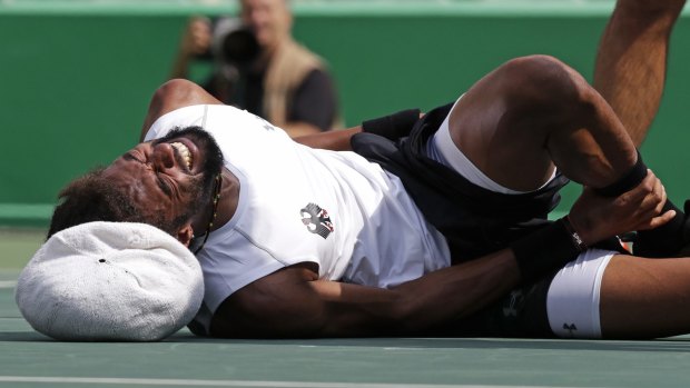 German Dustin Brown grabs his ankle after falling.