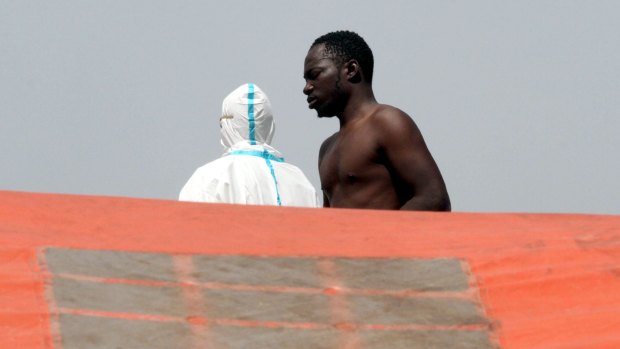 A migrant prepares to disembark from the Italian Navy Vega vessel, in Reggio Calabria, Italy after being rescued in the Mediterranean Sea off the coasts of Libya. 
