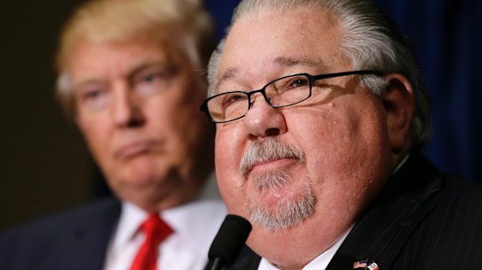 Sam Clovis speaks during a news conference as then-Republican presidential candidate Donald Trump, left, watches before a campaign rally in Dubuque, Iowa. 
