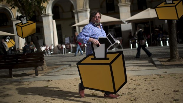 Businessman Emilio Busquets holds a drawing of a ballot box to decorate his shop ahead of voting on Catalan independence.