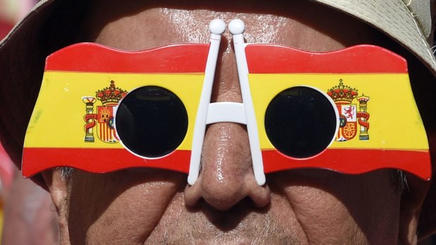 A Catalan signals his opposition to independence by wearing glasses bearing the Spanish flag.