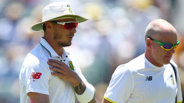 Big blow: South African fast bowler Dale Steyn leaves the field with the team physio after injuring his shoulder.