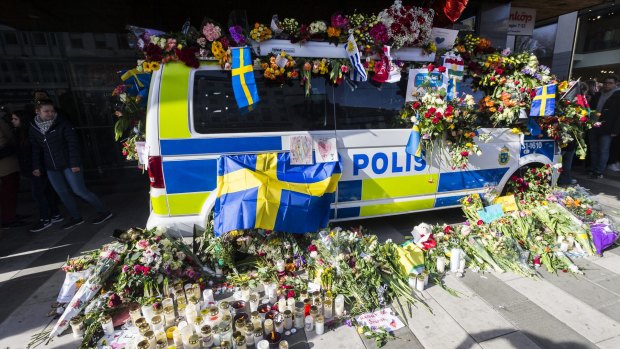 Flowers are left on a police car to show their gratitude to law enforcement officers after a peace demonstration on Sergels square on Sunday in Stockholm, Sweden.