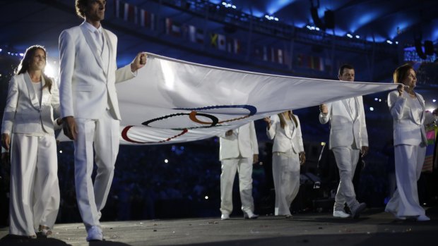 The Olympic flag is carried by Brazilian legends.