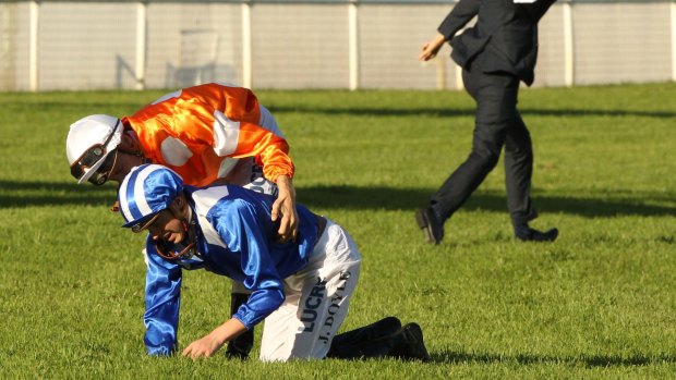 Helping hand: James Doyle is helped up by fellow jockey Blake Shinn after his horse Almoonqith broke down in the Sydney Cup.