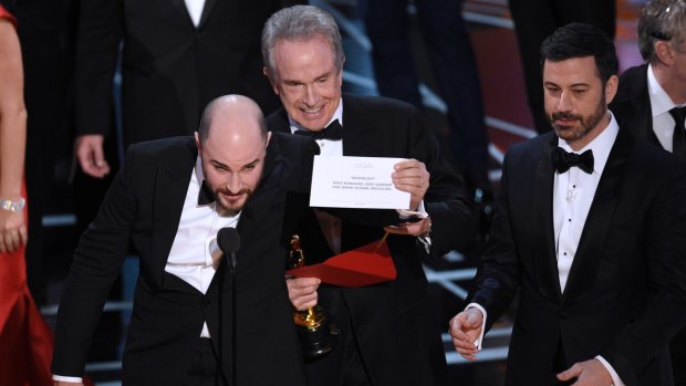 Jordan Horowitz, producer of "La La Land," shows the envelope revealing Moonlight as the true winner of best picture, with Warren Beatty and host Jimmy Kimmel at right.