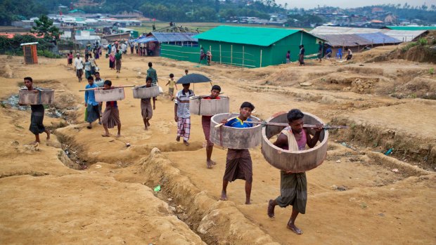 Rohingya refugees carry construction material to the Jamtoli refugee camp in Ukhiya, Bangladesh, on Friday.