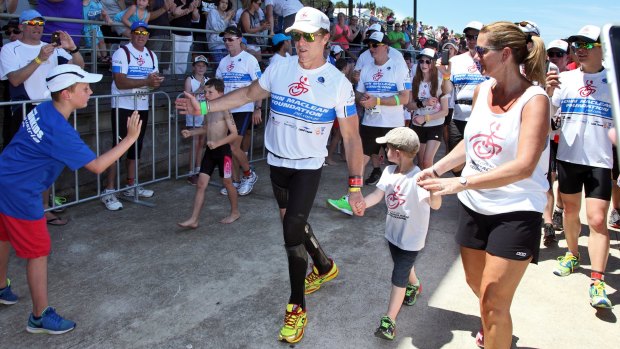 John Maclean crosses the finish line at the Nepean Triathlon with his wife Amanda and son Jack in 2014. 