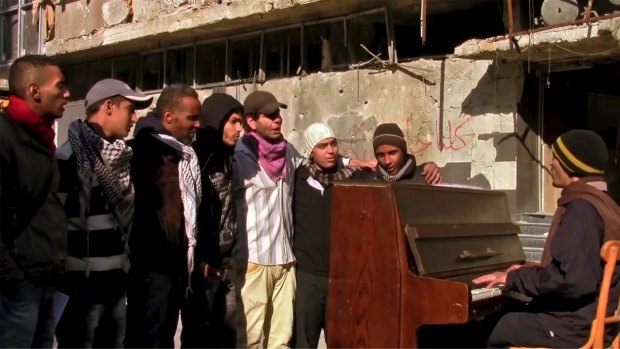 Ayham al-Ahmad leads Palestinian youth in song in Yarmouk in the film <i>Blue</i>.