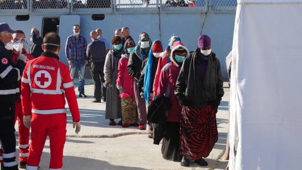 Safe landing: Refugees rescued by a Spanish navy vessel involved in Operation Triton line up in Sicily.