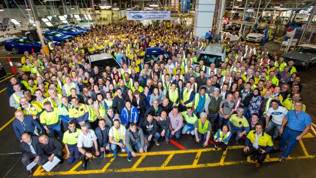 Job done: Ford employees gather around the Falcon XR6 after it rolled off the assembly line in Melbourne.