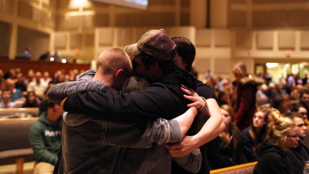 Members of the community pray before the start of the Kalamazoo community prayer service for the shooting victims on Sunday.