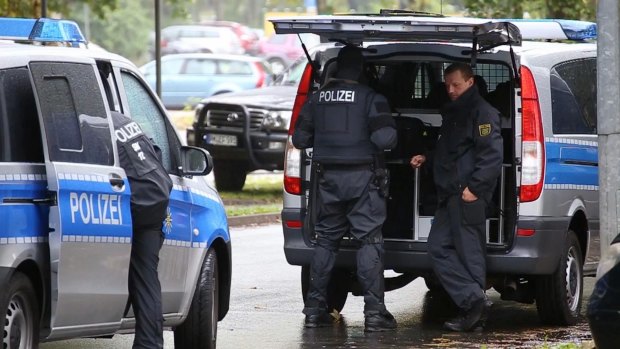 Police officers surround an apartment in the eastern city of Chemnitz, where German police are searching for a man suspected to have been planning a bombing attack.