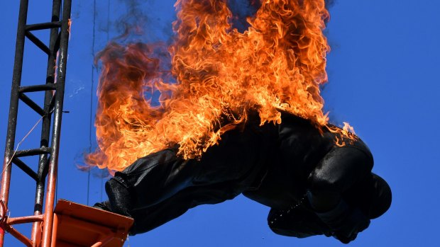 A stuntman on fire, dives from the high dive platform during the Western High Dive Show.