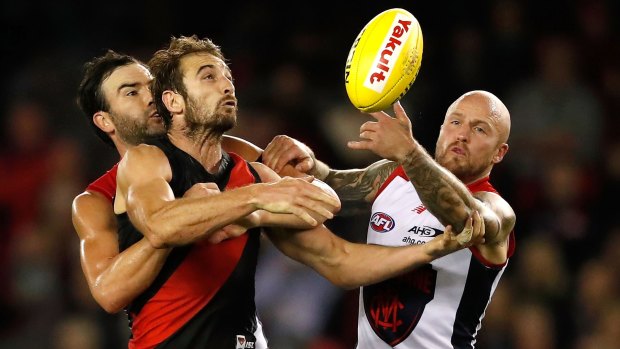 Essendon's Jobe Watson is tackled by Jordan Lewis (left) and Nathan Jones.