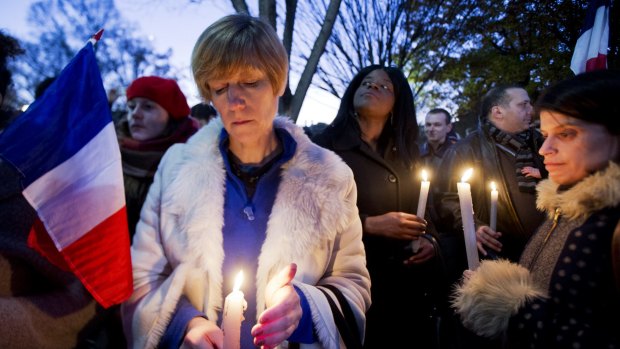 Alexandra Salomon, from Paris, France, centre, joins a vigil outside the White House in Washington DC.