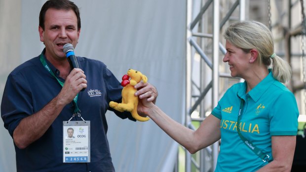 Rio de Janeiro Mayor Eduardo Paes (L) gets a toy kangaroo from the Australian delegation head Kitty Chiller during a ceremony at the Olympic Village on Wednesday.