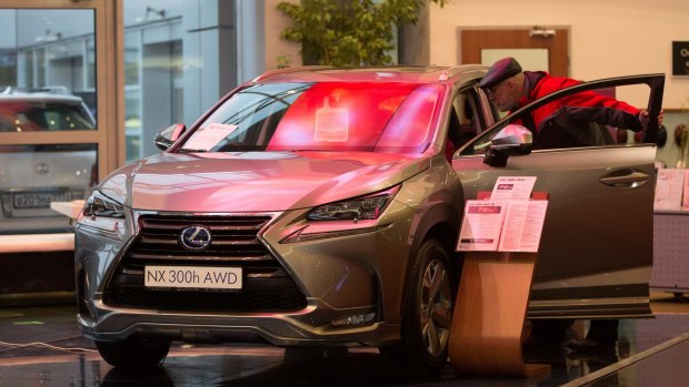 Will this hold value? A customer inspects a car for sale at a Lexus automobile dealership in Moscow.