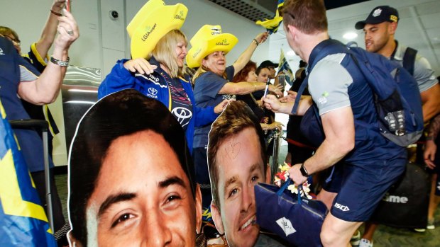 Hard to leave this support: Michael Morgan autographs a poster cutout at Townsville Airport.
