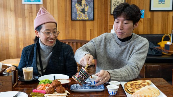 Chef Jung Eun Chae and her husband Yoora Yoon tuck into a falafel platter, cheese pie and labne pizza at A1 Bakery.
