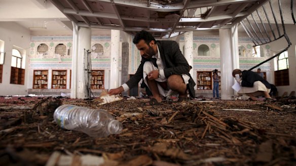 Crime scene investigators look at the ground after a suicide bomb attack at a mosque in Sanaa.