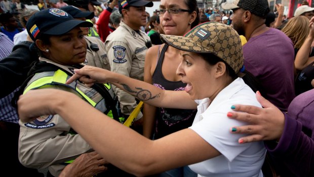 A woman argues with the police during a protest for food in Caracas, Venezuela.