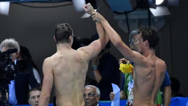 Cameron McEvoy, right, raises Kyle Chalmers' arm in triumph.
