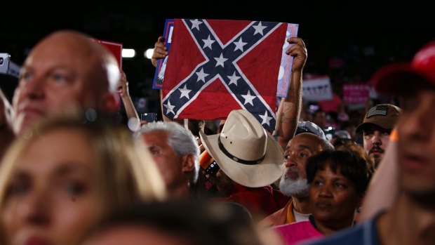 The Confederate flag is held aloft at a Trump rally in Tampa, Florida.