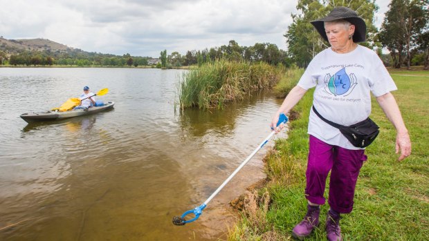 Tuggeranong Lake Carers Group members Lesley McGrane and Bill Perry remove rubbish from the lake.