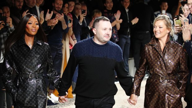 Designer Kim Jones, accepts applause as he walks with models Kate Moss and Naomi Campbell after his Louis Vuitton men's Fall-Winter 2018/2019 fashion collection presented in Paris.
