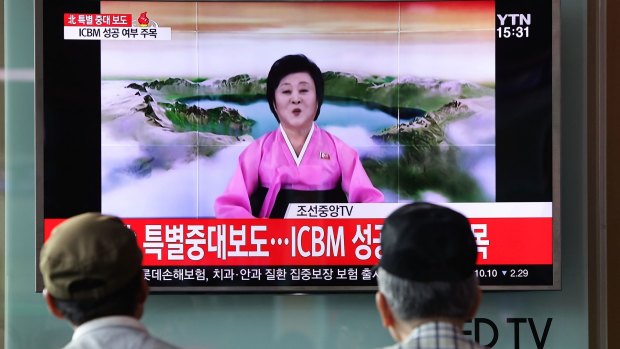 People watch North Korea's KRT television announcing the launch of an intercontinental ballistic missile.