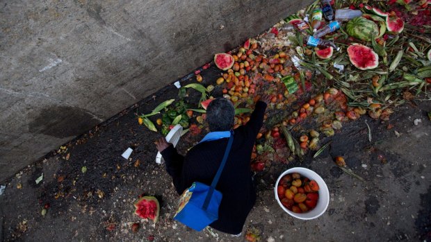 Pedro Hernandez goes through discarded tomatoes from the trash area of the Coche public market in Caracas, Venezuela. 