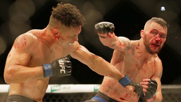 Townsville's Damien Brown, right, trades blows with Jon Tuck of Guam at Rod Laver Arena in November.