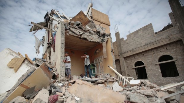 Boys stand on the remains of a house destroyed by Saudi-led airstrikes in Yemen in August.  