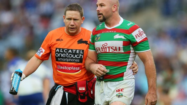 Blow: Glenn Stewart of the Rabbitohs is assisted from the field.