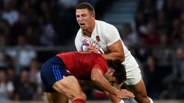 No regrets: Sam Burgess is tackled by France's Remi Lamerat in a World Cup match last year.