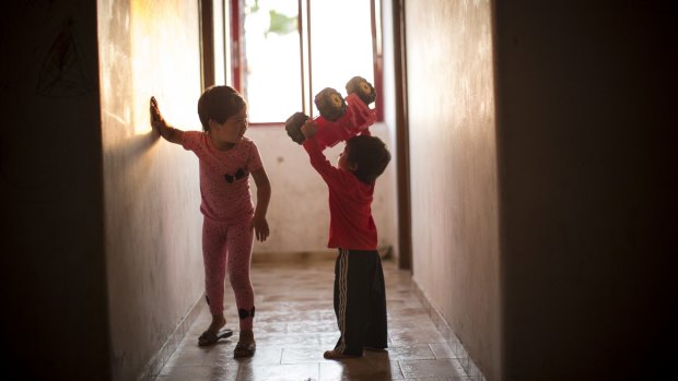 More fortunate ones: Afghan children play in the corridor of an abandoned hotel that has given refuge to many migrant families on Kos.