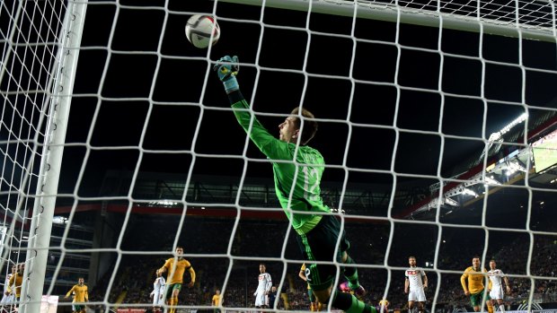 German goalkeeper Ron-Robert Zieler dives in vain as Mile Jedinak scores Australia's second goal during a friendly match in 2015.