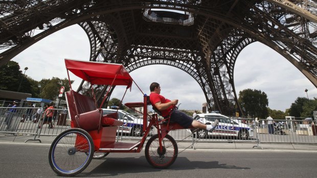 A bicycle taxi sits in the shadow of the Eiffel Tower. UN talks in Germany this week are paving the way for the Paris climate summit starting on November 31.