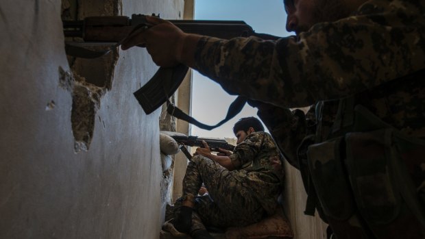 Members of the Syrian Democratic Forces, a militia made up of Syrian Kurds and Arabs, monitor and fire at what they believed were Islamic State fighters in Raqqa, Syria, on October 12.
