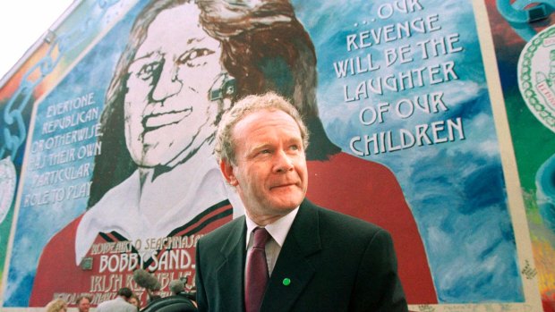 Martin McGuinness in front of a mural of Bobby Sands on the Falls Road in West Belfast in  2001. 