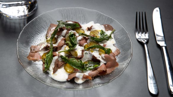 Beef heart with mustard leaves, white sauce and pickles.
